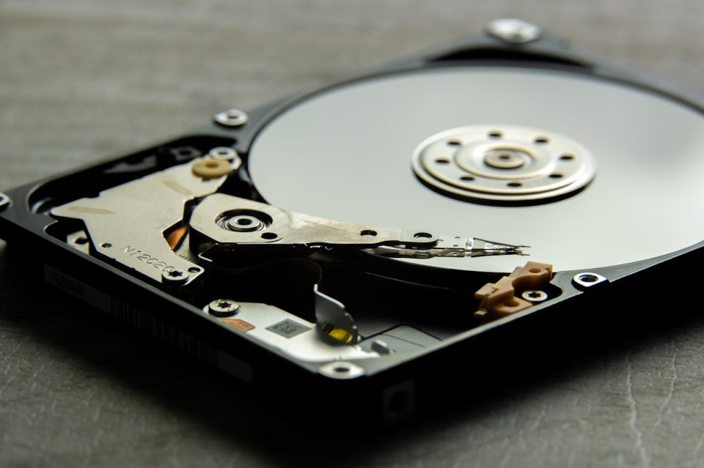 Detailed view of an open hard drive, showcasing the disk platter and actuator arm.